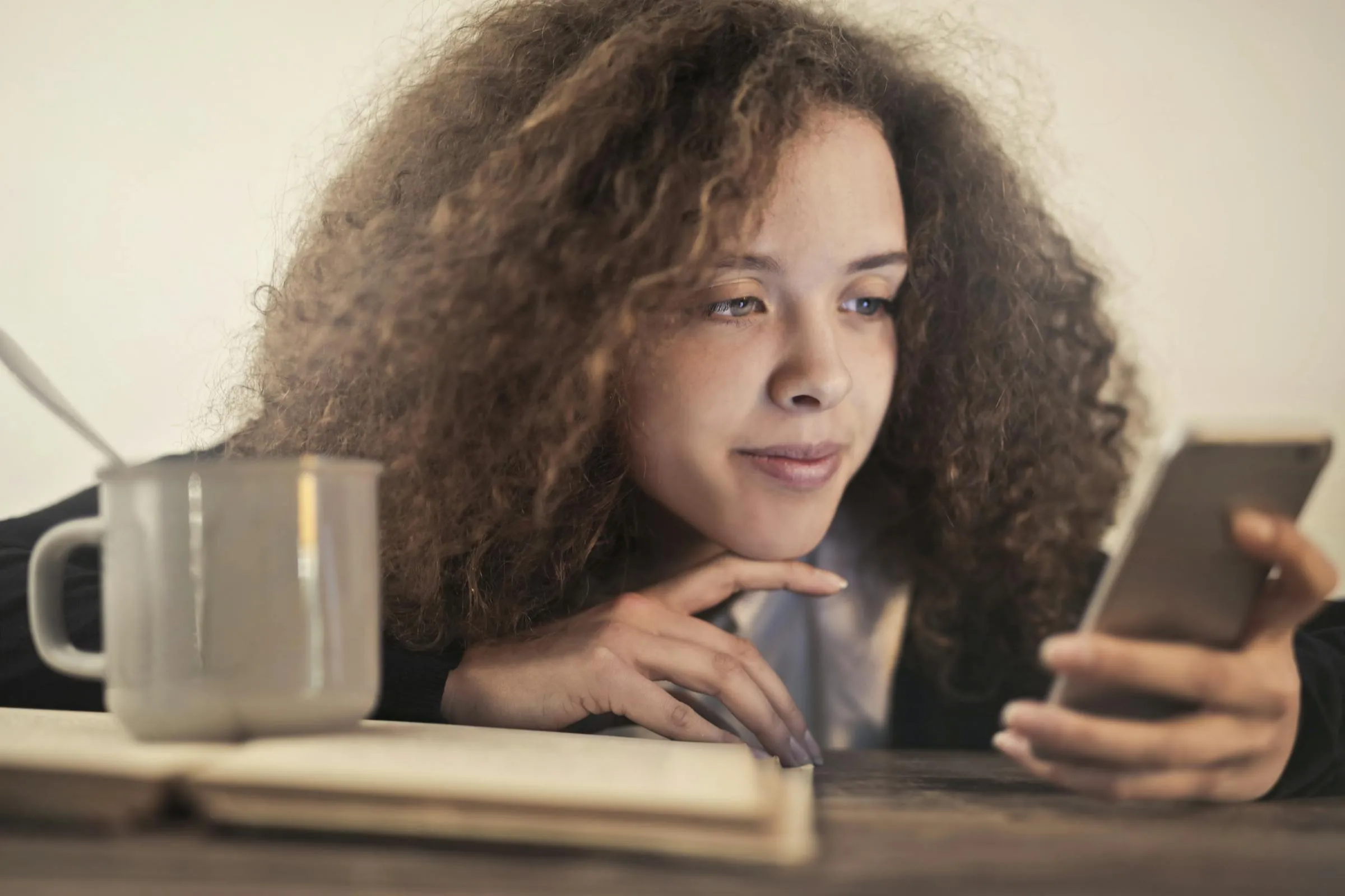 Person checking phone in a coffee shop