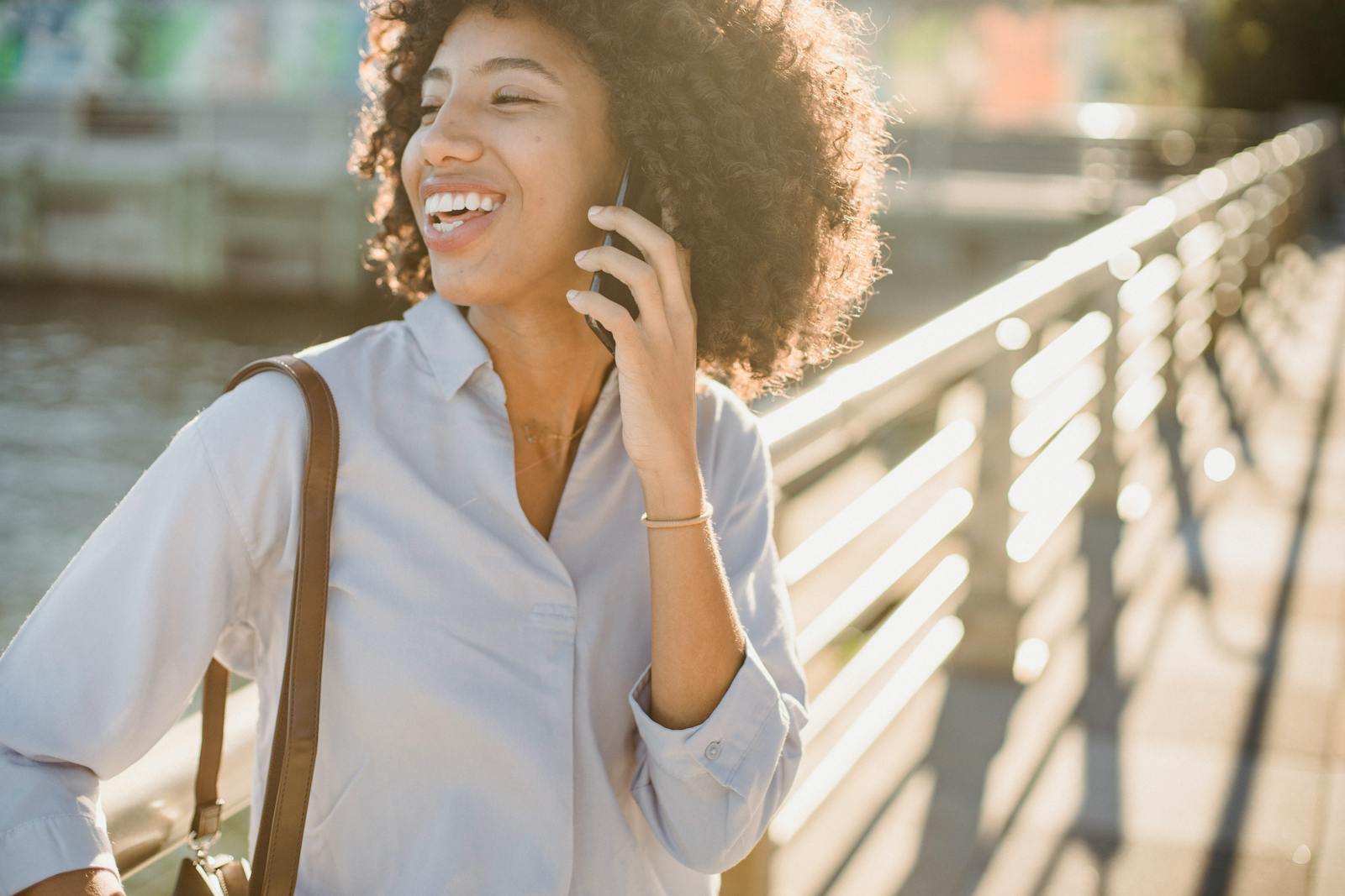 Woman laughing while talking on the phone in golden light