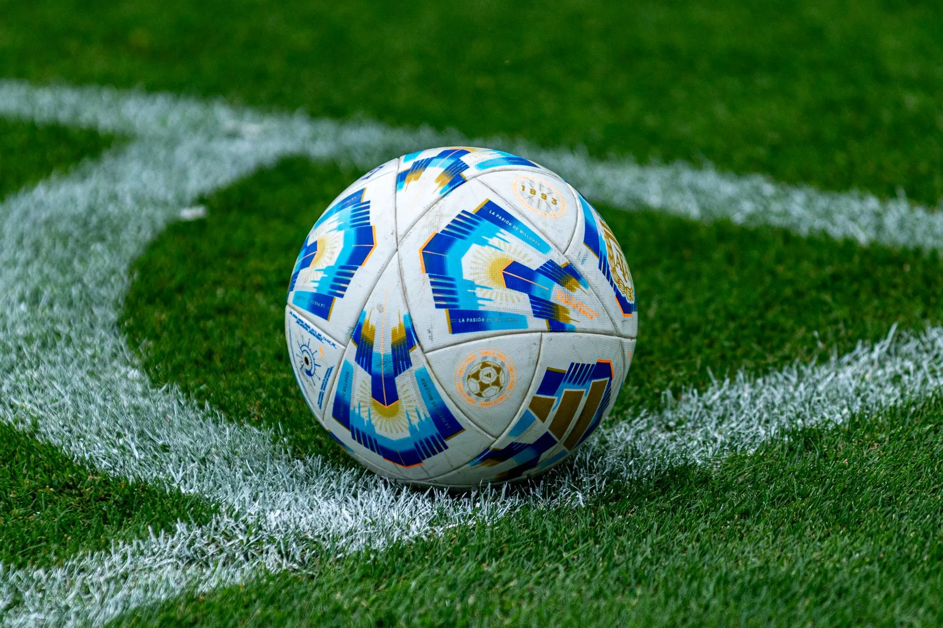 Modern colorful soccer ball on a green pitch at a stadium